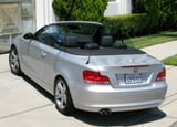 A three-quarter rear view of a silver 2008 BMW 128i Convertible