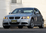 A three-quarter front view of a silver 2011 BMW 335i