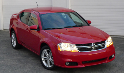 A three-quarter front view of a red 2012 Dodge Avenger SXT Plus