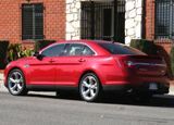 A three-quarter rear view of a red 2010 Ford Taurus SHO