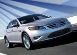 A three-quarter front view of a silver 2010 Ford Taurus