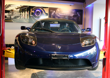 A front view of a dark blue 2008 Tesla Roadster on display at Tesla Motor's Los Angeles dealership
