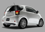 A three-quarter rear view of a white 2011 Scion iQ