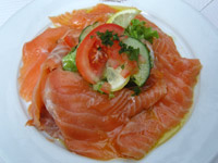 A plate of smoked salmon with tomatoes and cucumbers A plate of smoked salmon with tomatoes and cucumbers
