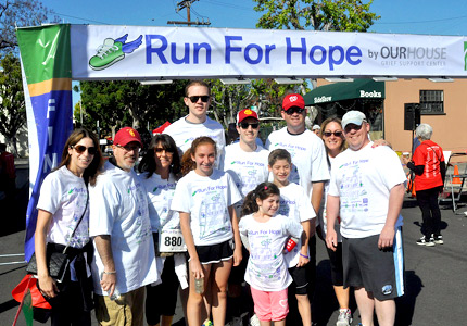 Race attendees smile for a photo at the finish line Race attendees smile for a photo at the finish line