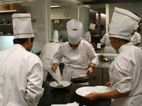A group of chefs plating a dish