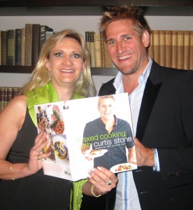 Chef Curtis Stone showing his new book to Sophie Gayot