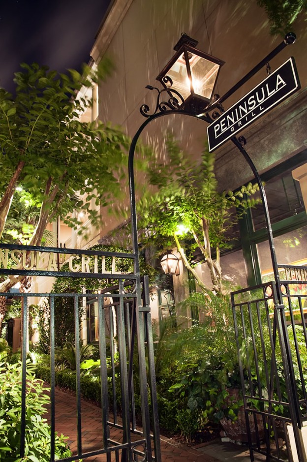 The Peninsula Grill entrance features flickering carriage lanterns and hand-pointed brick walkways