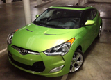 A three-quarter front view of a green 2012 Hyundai Veloster