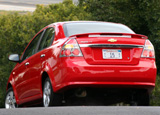 A three-quarter rear view of a red 2008 Chevrolet Aveo LT