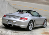 A three-quarter rear view of a silver 2011 Porsche Boxster Spyder