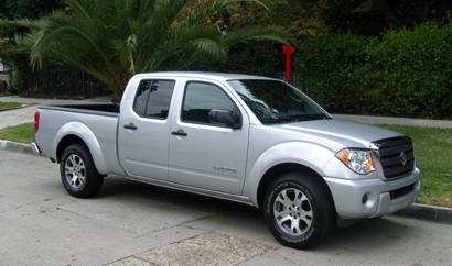 A three-quarter front view of a silver 2009 Suzuki Equator