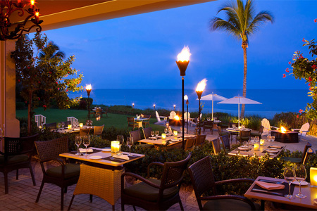 Indoor-outdoor seating overlooks a swath of beach and Gulf of Mexico at Naples' most elegant hotel restaurant.