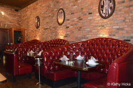 Brick walls, tin ceilings and giant red leather booths set the stage at Capo's Chicago Pizza & Fine Italian Dinners