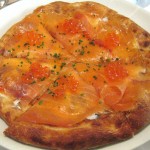House smoked salmon pizza with shaved sweet onions, dill cream and salmon pearls