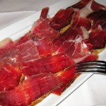 Platter of pata negra cured ham, "bellota bellota" variety, with tomato on a slice of bread
