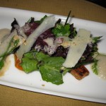 Green salad accompanied with black trumpet mushrooms and hazelnuts in a foie gras emulsion