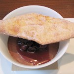 White sesame pot de crème with chocolate glaze, cherries and bugnes lyonnaise pastry