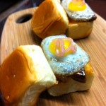 Foie gras sliders topped with quail egg, pickled shallots and spicy apple beer mustard