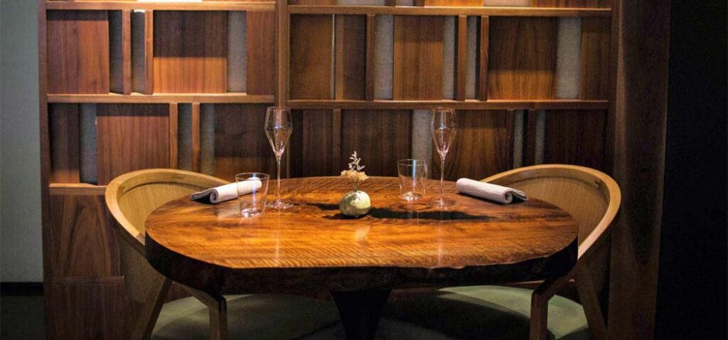 A handmade walnut table in the intimate dining room of chef Dominique Crenn's Atelier Crenn